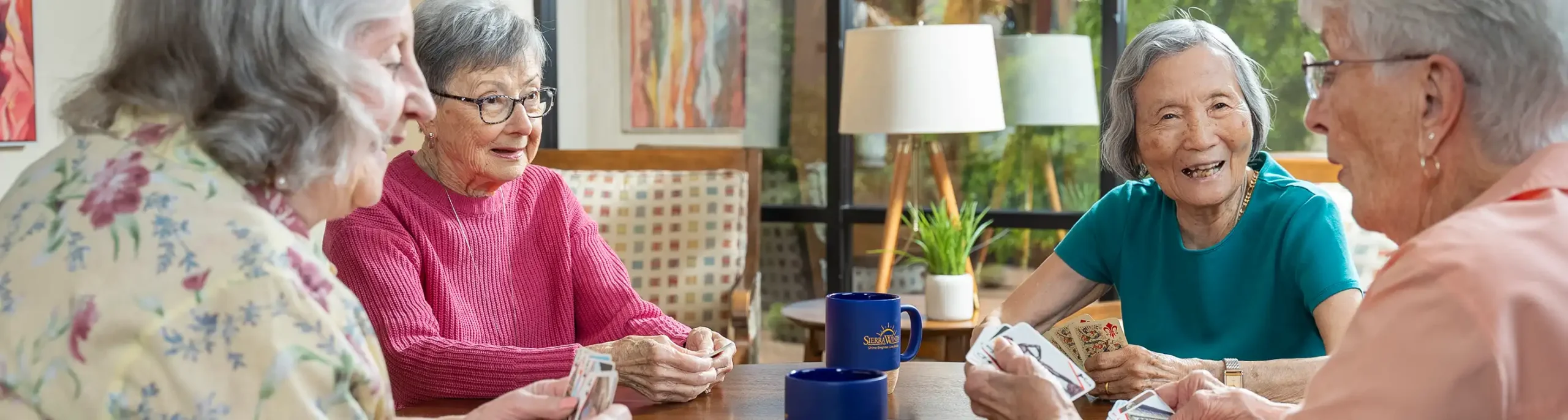 About Sierra Winds Senior Living health care - seniors playing cards at a table, supportive services